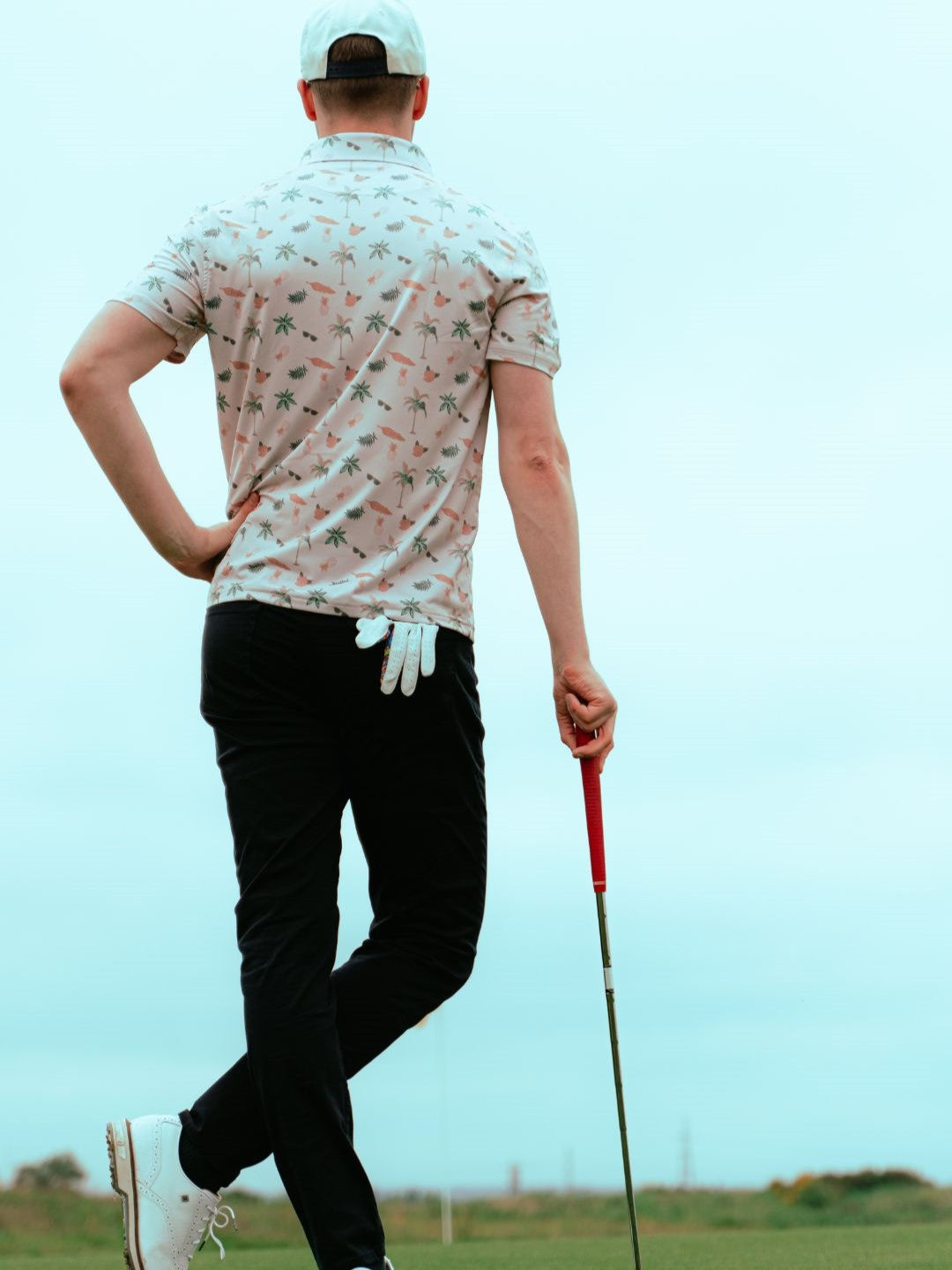 golfer standing on green wearing polo